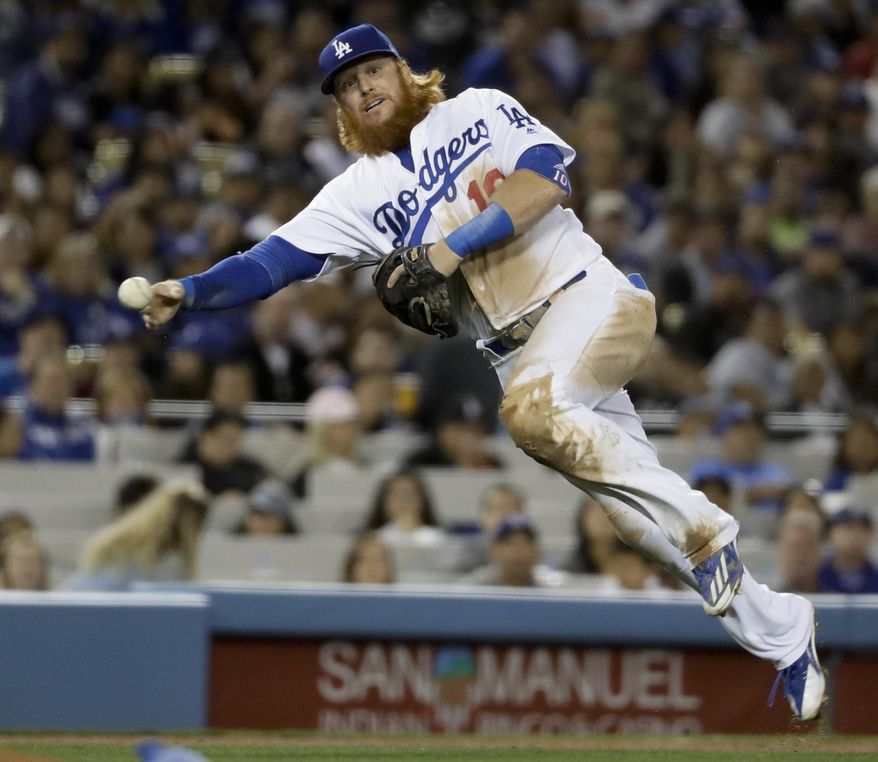 Los Angeles Dodgers third baseman Justin Turner fails to throw out Miami Marlins' Justin Bour at first during the sixth inning of a baseball game in Los Angeles, Thursday, May 18, 2017. (AP Photo/Chris Carlson)