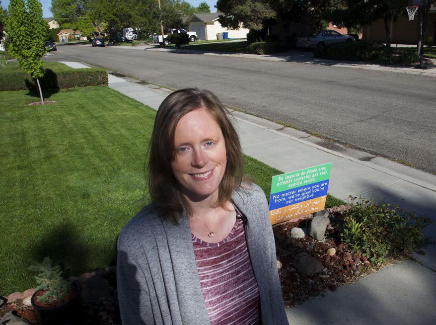 In this May 10, 2017, photo Lauresta Welty poses for a photo next to a sign in front of her home in Boise, Idaho. "We want to spread love and hope to each other, our neighbors, and to everyone," said Welty. (Darin Oswald/Idaho Statesman via AP)