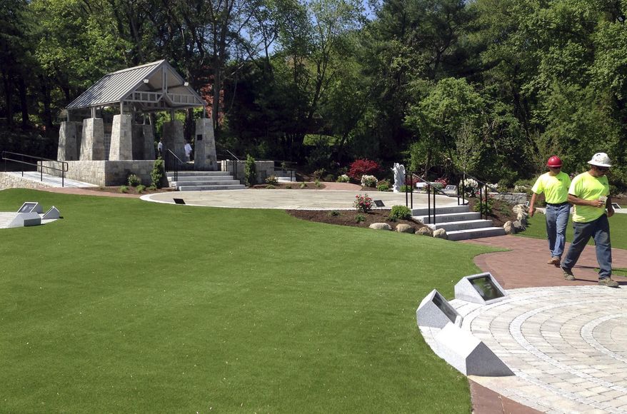 Workers finalize details at a memorial in West Warwick, R.I., on Friday, May 19, 2017, at the site of The Station nightclub fire that killed 100 and injured more than 200 people in 2003. The memorial is scheduled to open during a ceremony Sunday. (AP Photo/Michelle R. Smith)