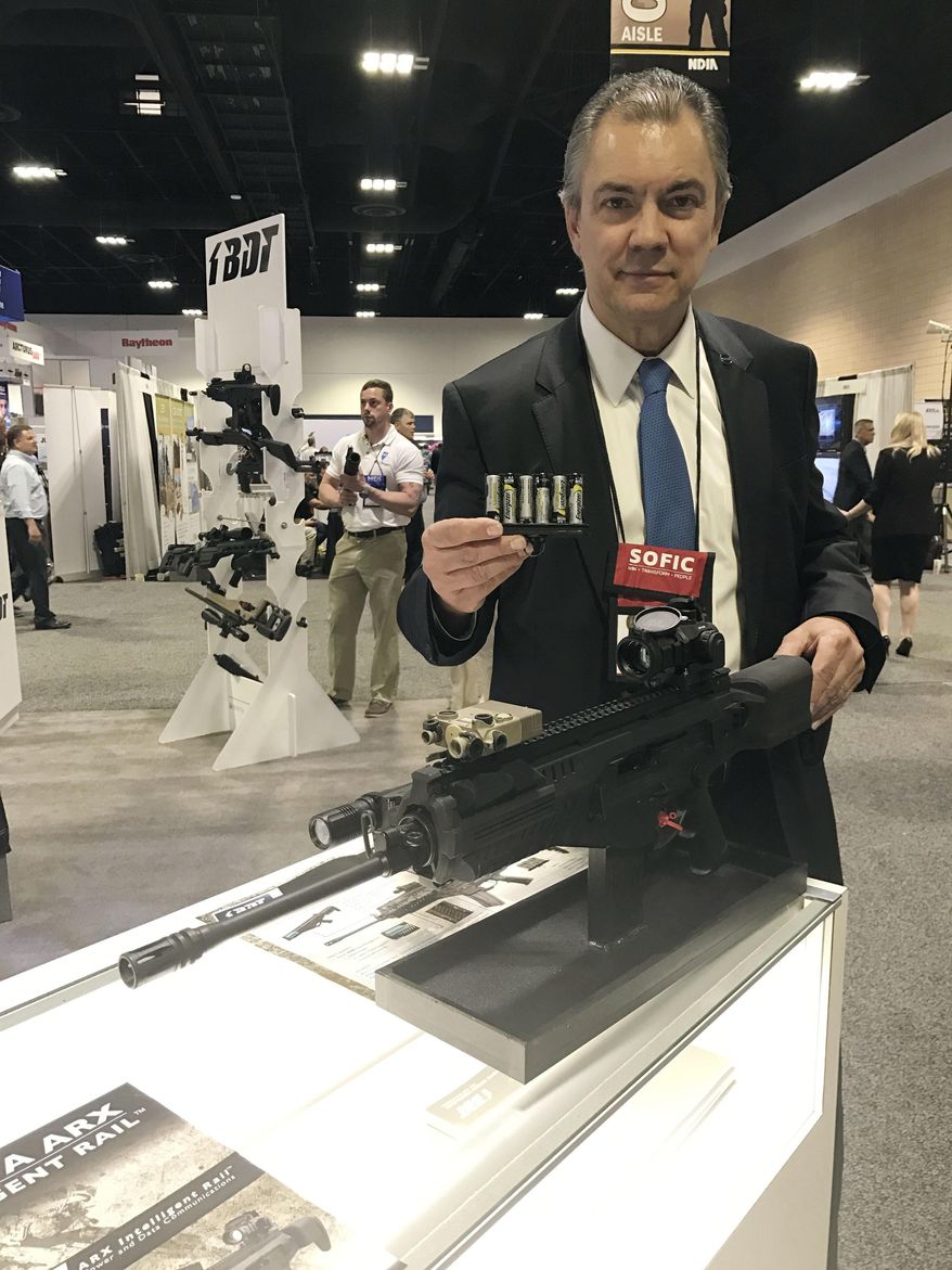 In this photo taken Tuesday, May 16, 2017, Gabriele de Plano, vice president of BDT marketing and operations of Beretta, displays a prototype of a rifle during the Special Operations Forces Industry Conference in Tampa, Fla. The conference is for military special operations forces featuring gadgets, weapons and tools. (AP Photos/ Tamara Lush)