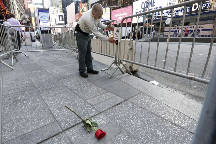 A building worker posts a "Rest in Peace" sign for the victim of a wrong way driver in New York's Times Square, Friday, May 19, 2017. Richard Rojas, 26, charged with slamming his speeding car into pedestrians on the sidewalks of Times Square, killing a teenage tourist and injuring nearly two dozen people, said he wanted to "kill them all" and police should have shot him to stop him, a prosecutor revealed Friday. (AP Photo/Richard Drew)