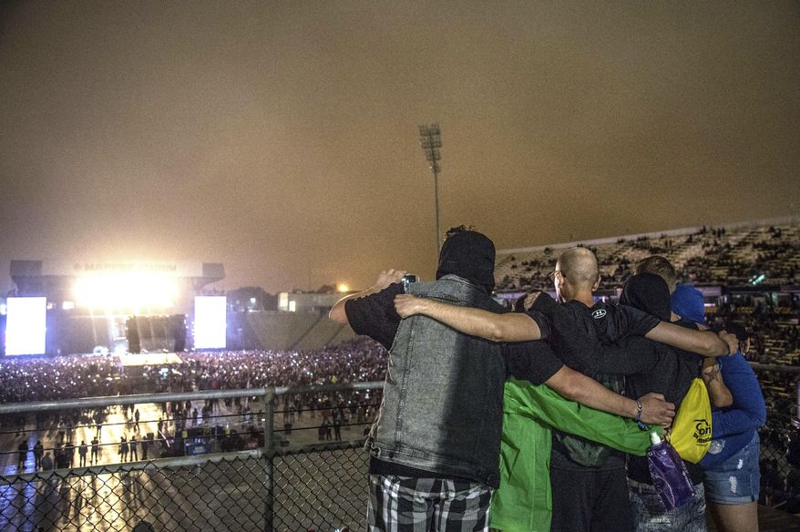 Festival goers embrace during a tribute to Chris Cornell performed by Corey Taylor at Rock On The Range Music Festival on Friday, May 19, 2017, in Columbus, Ohio. (Photo by Amy Harris/Invision/AP)