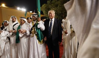 President Donald Trump holds a sword and sways with traditional dancers during a welcome ceremony at Murabba Palace, Saturday, May 20, 2017, in Riyadh. (AP Photo/Evan Vucci)