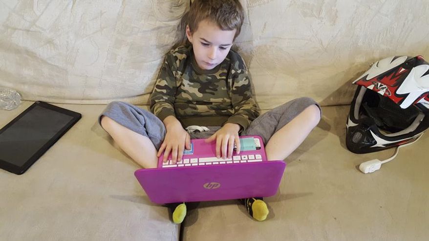 In a May 1, 2017 photo, Preston Merritt, 7, works on an interactive school assignment at his home in Walla Walla, Washington. Preston is enrolled in the first grade through Washington Connection Academy, an online school that was approved in the state in 2016. (Sheila Hagar/Walla Walla Union-Bulletin via AP)