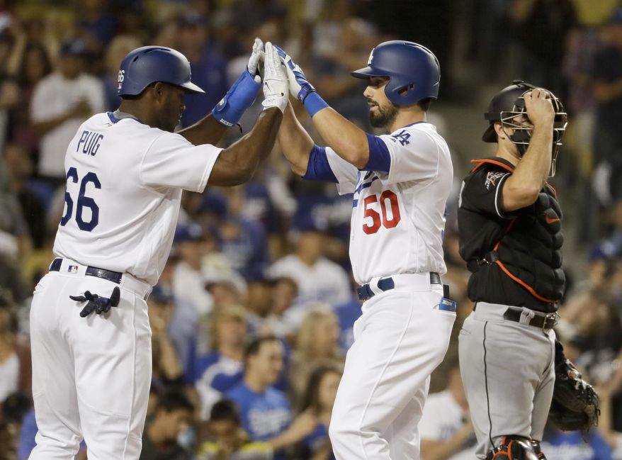 Los Angeles Dodgers' Brett Eibner, middle, celebrates his two-run home run with Yasiel Puig, left, next to Miami Marlins catcher J.T. Realmuto during the fourth inning of a baseball game in Los Angeles, Friday, May 19, 2017. (AP Photo/Chris Carlson)
