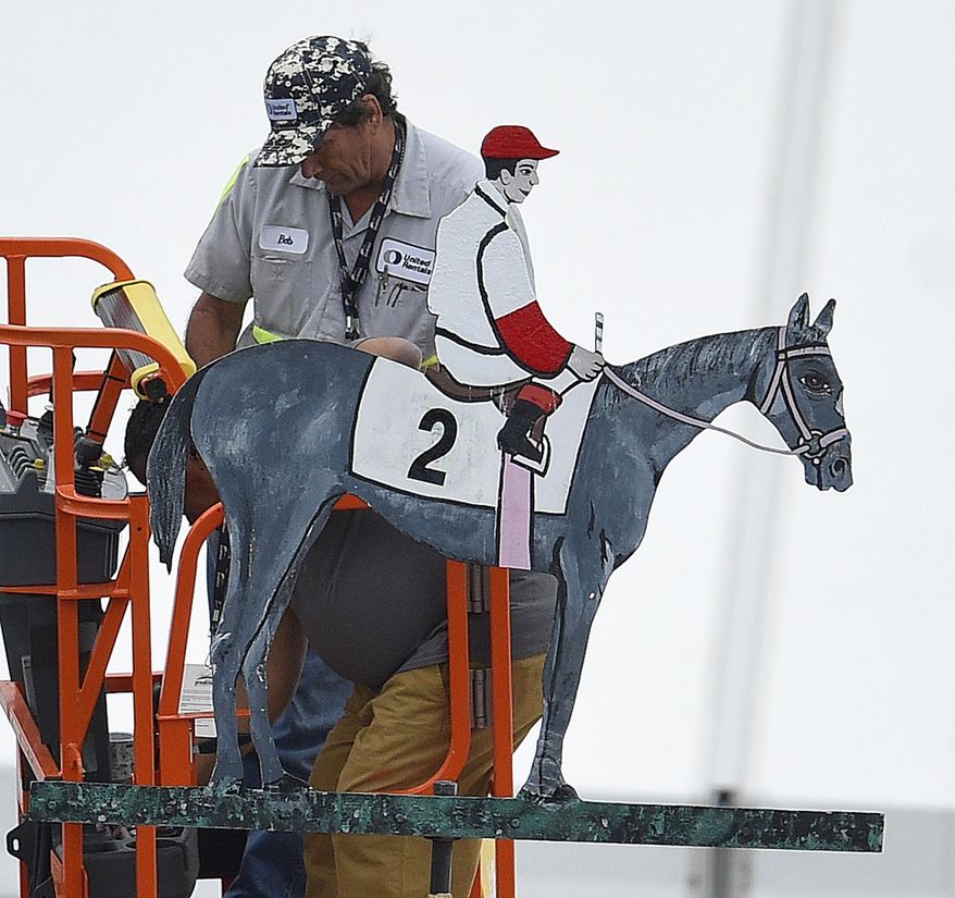 Workers paint the weather vane in the colors of Cloud Computing ridden by Javier Castellano after they won the 142nd Preakness Stakes horse race at Pimlico race course, Saturday, May 20, 2017, in Baltimore. (AP Photo/Nick Wass)