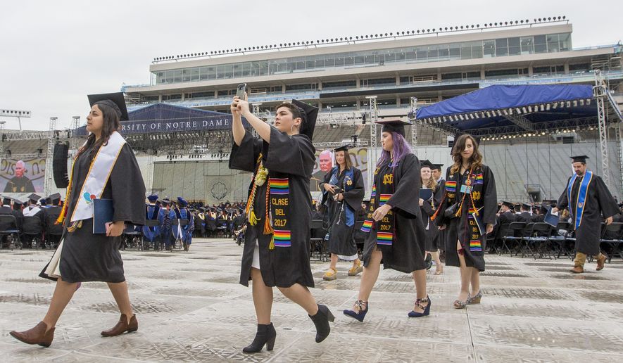 Notre Dame graduates walk out of Notre Dame Stadium in protest as Vice President Mike Pence speaks at the 2017 commencement ceremony Sunday, May 21, 2017, in South Bend, Ind. (Robert Franklin/South Bend Tribune via AP)