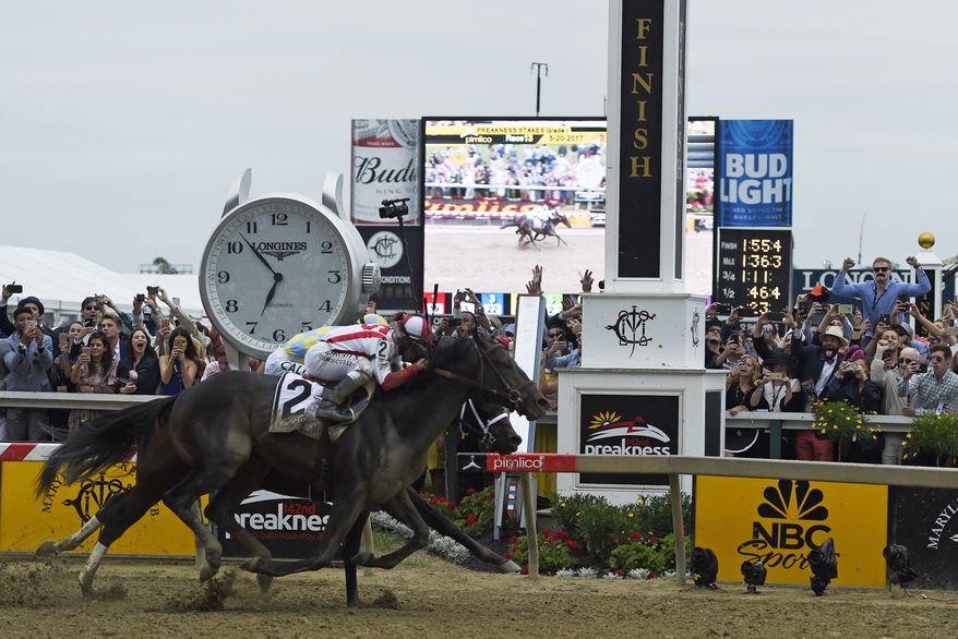 Cloud Computing (2), ridden by Javier Castellano, wins the 142nd Preakness Stakes horse race at Pimlico race course as Classic Empire with Julien Leparoux aboard takes second, Saturday, May 20, 2017, in Baltimore. NFL football player Baltimore Ravens first-round draft pick Marlon Humphrey, far left, cheers the finish. (AP Photo/Mike Stewart) **FILE**