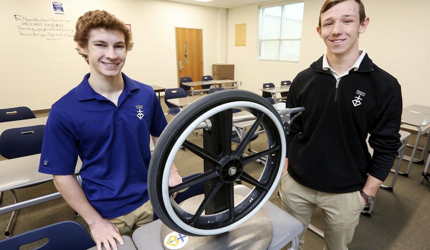 In this Monday, April 24, 2017 photo, Wahlert Catholic High School seniors Tony Ward, left, and Grant Oberfoell, who helped to create the Feltes One Way, pose with it at Wahlert Catholic High School in Dubuque, Iowa. (Nicki Kohl /Telegraph Herald via AP)