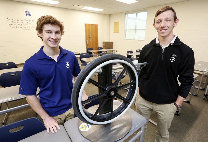 In this Monday, April 24, 2017 photo, Wahlert Catholic High School seniors Tony Ward, left, and Grant Oberfoell, who helped to create the Feltes One Way, pose with it at Wahlert Catholic High School in Dubuque, Iowa. (Nicki Kohl /Telegraph Herald via AP)