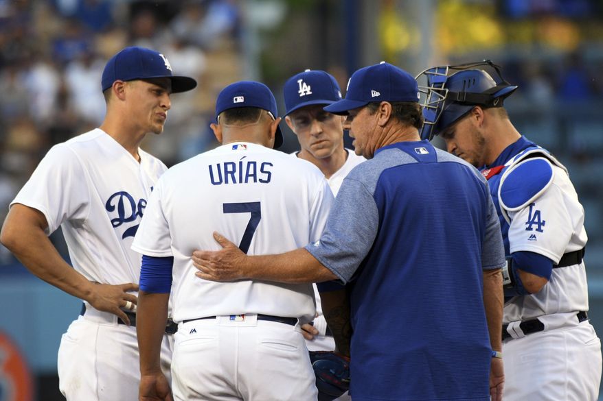 Los Angeles Dodgers' pitching coach Rick Honeycutt, front right, talks with Julio Urias, who loaded the bases with no outs, against the Miami Marlins in the first inning of a baseball game in Los Angeles, Saturday, May 20, 2017. (AP Photo/Michael Owen Baker)