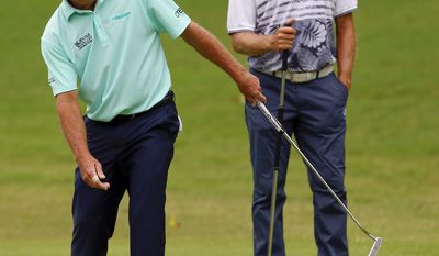 Fred Funk, left, reacts to missing a birdie putt on the first hole as Bernhard Langer, of Germany, watches during the Regions Tradition PGA Tour Champions golf tournament, Sunday, May 21, 2017, in Birmingham, Ala. (Photo/Butch Dill)