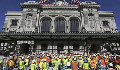 FILE – In this April 8, 2014, file photo, construction workers listen to a safety talk by a manager in front of Union Station, undergoing renovation and expansion, in Denver. Rollout of the Government Accounting Standards Board&#39;s reporting rules for economic development tax breaks has not been without hiccups, with the nonprofit board issuing an April 2017 clarification about tax increment financing, or TIF, districts. The mechanism was used to develop Union Station and other projects nationwide. (AP Photo/Brennan Linsley, File)