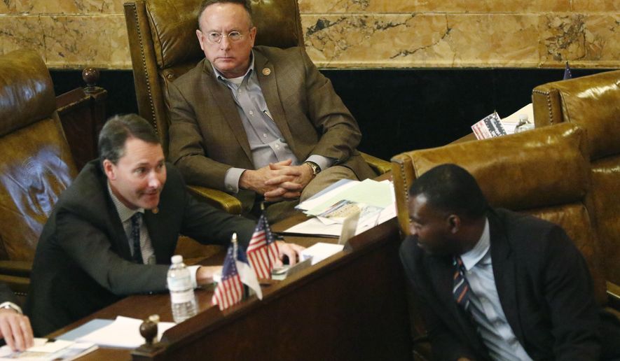 In this Jan. 30, 2017, photo, Rep. Karl Oliver, R-Winona, rear, listens to Reps. Sam Mims, R-McComb, foreground left, confer with Bryant Clark, D-Pickens, during the 2017 Legislature at the Capitol in Jackson, Miss. Oliver apologized Monday, May 22, for saying on his Facebook page that Louisiana leaders should be lynched for removing Confederate monuments, only after his comment sparked broad condemnation in both states. (AP Photo/Rogelio V. Solis)