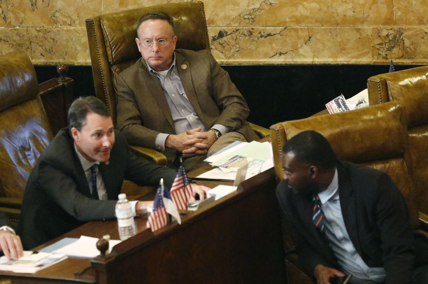 In this Jan. 30, 2017, photo, Rep. Karl Oliver, R-Winona, rear, listens to Reps. Sam Mims, R-McComb, foreground left, confer with Bryant Clark, D-Pickens, during the 2017 Legislature at the Capitol in Jackson, Miss. Oliver apologized Monday, May 22, for saying on his Facebook page that Louisiana leaders should be lynched for removing Confederate monuments, only after his comment sparked broad condemnation in both states. (AP Photo/Rogelio V. Solis)