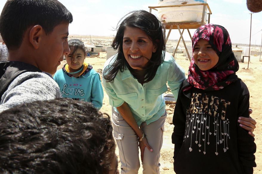 U.S. Ambassador to the United Nations Nikki Haley, speaks with Syrian refugee children, during a visit to the Zaatari Refugee Camp, Jordan, Sunday, May 21, 2017. Haley said the Trump administration wants to step up help for the millions of people displaced. Yet Nikki Haley's message is at odds with President Donald Trump's "America First" agenda, his planned budget cuts and his hardline position on admitting refugees. (AP Photo/Raad Adayleh, Pool)