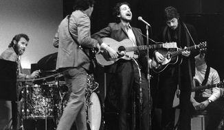 FILE - In this Jan. 20, 1968 file photo, folk singer Bob Dylan, center, performs with drummer Levon Helm, left, Rick Danko, second left, and Robbie Robertson of The Band at Carnegie Hall in New York. For most of 1967, Bob Dylan quietly made history in a basement outside of Woodstock, New York. With the gifted musicians who later named themselves Band, he sang dozens of old country and Appalachian ballads, along with such originals as “I Shall Be Released” and “Tears of Rage.”  (AP Photo, File)