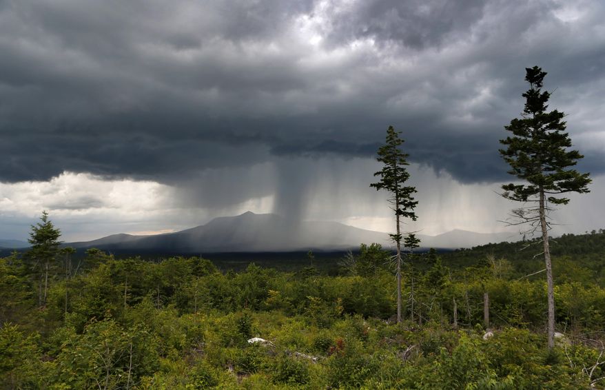 FILE - In this August 2015 file photo, a rain storm passes over Mt. Katahdin in this view from land that is now the Katahdin Woods and Waters National Monument in northern Maine. Motorists on Interstate 95 in Maine won't see signs directing them to the new national monument created by President Barack Obama because Gov. Paul LePage is refusing to let the state install them. (AP Photo/Robert F. Bukaty, file)