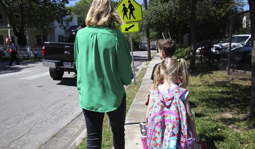 In this May 4, 2017, photo Joanna Smith, of Houston, walks her twin first-graders home from school. One of her children is transgender and Smith fears the child's school would be compelled by the state to "out" her child's biological gender should a "bathroom bill" become law. (AP Photo/John L. Mone)
