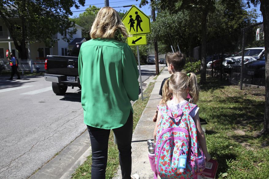 In this May 4, 2017, photo Joanna Smith, of Houston, walks her twin first-graders home from school. One of her children is transgender and Smith fears the child's school would be compelled by the state to "out" her child's biological gender should a "bathroom bill" become law. (AP Photo/John L. Mone)