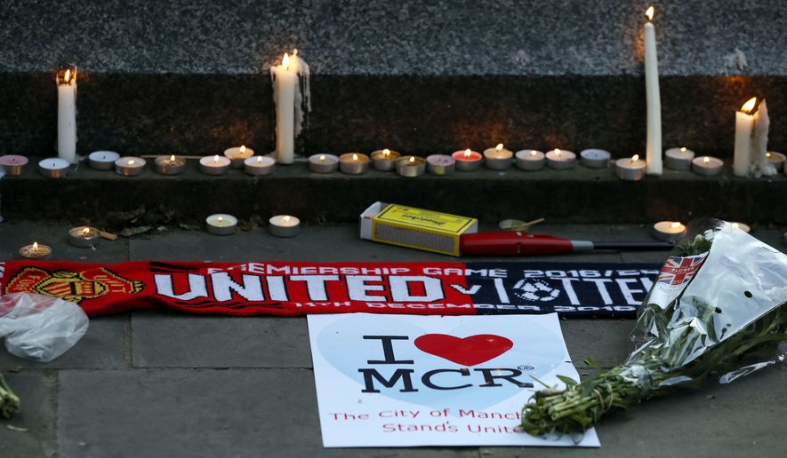 Candles and tributes were left after a vigil in Albert Square, Manchester, England, on Tuesday, the day after a suicide attack at an Ariana Grande concert attended by many young people. (Associated Press)