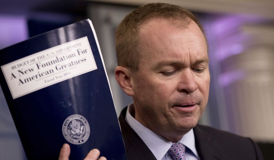 Budget Director Mick Mulvaney holds up a copy of President Trump&#x27;s proposed fiscal 2018 federal budget as he speaks to members of the media at the White House on Tuesday. (Associated Press)