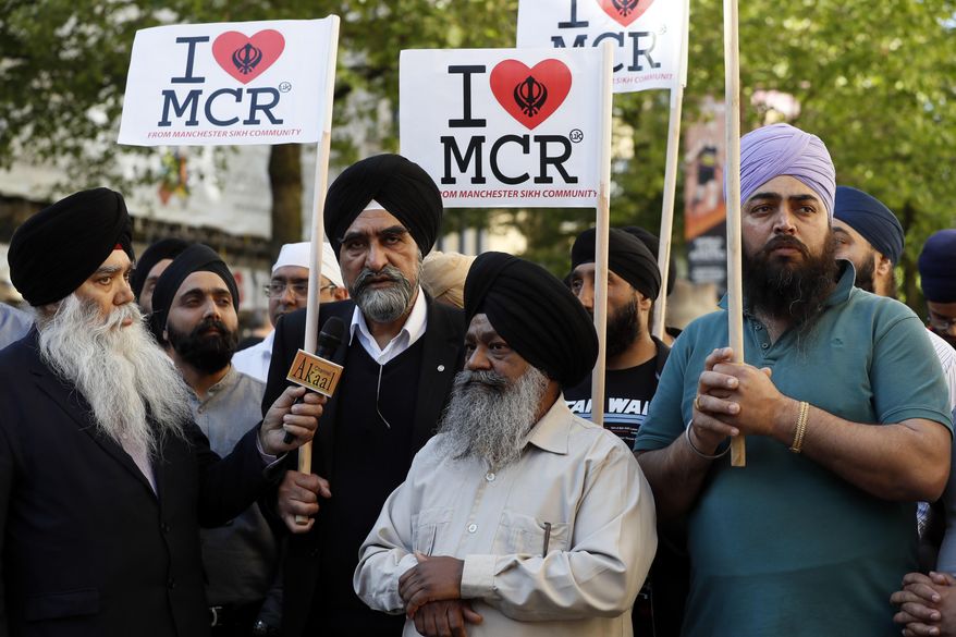 Members of the Manchester Sikh Community attend a vigil in Albert Square, Manchester, England, Tuesday May 23, 2017, the day after the suicide attack at an Ariana Grande concert that left 22 people dead as it ended on Monday night. (AP Photo/Kirsty Wigglesworth)