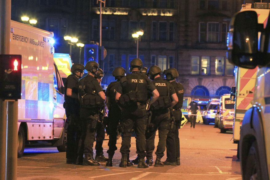 Armed police gather at Manchester Arena after reports of an explosion at the venue during an Ariana Grande gig in Manchester, England Monday, May 22, 2017. Several people have died following reports of an explosion Monday night at an Ariana Grande concert in northern England, police said. A representative said the singer was not injured. (Peter Byrne/PA via AP)