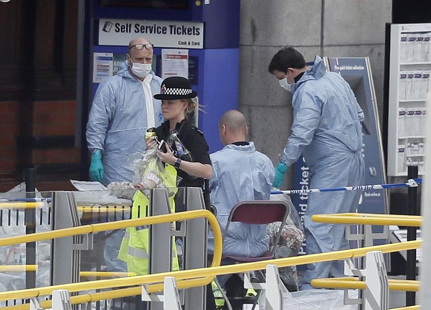 Forensic officers investigate the scene near the Manchester Arena, Manchester, England, Tuesday May 23, 2017, the day after the suicide attack at an Ariana Grande concert that left 22 people dead as it ended on Monday night. (AP Photo/Kirsty Wigglesworth)
