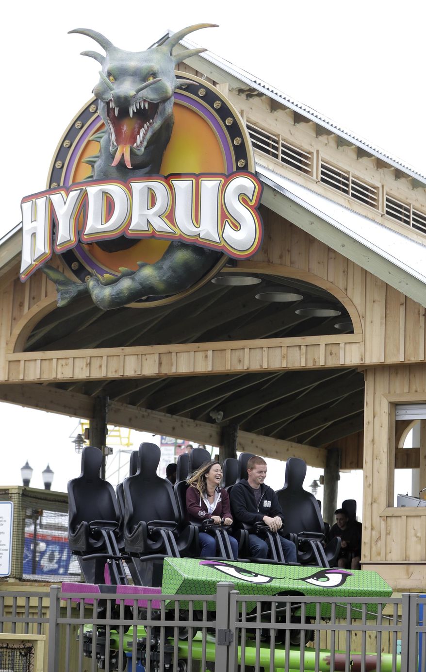 In this May 20, 2017, photo, people ride the Hydrus roller coaster, Saturday, May 20, 2017, at Casino Pier in Seaside Heights, N.J. More than four years after Superstorm Sandy destroyed part of the Casino Pier and left the since-demolished Jet Star roller coaster partially submerged in the Atlantic Ocean, the new roller coaster named Hydrus opened May 6, 2017, built safely inland above the beach rather than out over the water. (AP Photo/Julio Cortez)