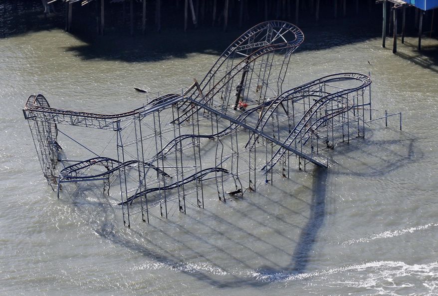 FILE – In this Nov. 9, 2012, file photograph, the Jet Star roller coaster remains partially submerged in the Atlantic Ocean after Superstorm Sandy destroyed part of the Casino Pier in Seaside Heights, N.J. A new roller coaster named Hydrus, built safely inland above the beach rather than out over the water, opened May 6, 2017, more than four years after the storm caused billions of dollars' worth of damage to the coast. (AP Photo/Mel Evans, File)