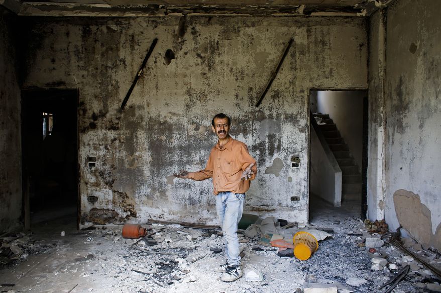 In this May 18, 2017 photo, Fayez Ghosn surveys damage inside his house at the mountain resort town of Zabadani in the Damascus countryside, Syria. Once a popular summer resort famed for its fruit trees and favored by tourists from rich Gulf Arab countries, Zabadani is now a deserted, endless vista of pulverized buildings after thousands of rebels were driven out along with the town's original inhabitants. (AP Photo/Hassan Ammar)