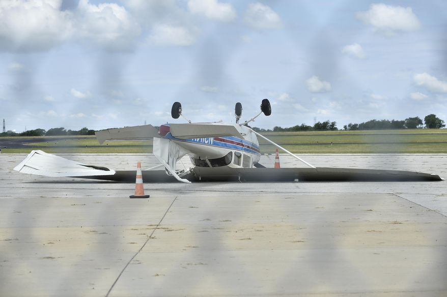 An overnight storm brought high winds that caused this small airplane to flip over at Denton Enterprise Airport, Tuesday, May 23, 2017, in Denton, Texas. Authorities say more than a dozen small planes have been damaged as storms packing strong winds struck the North Texas airport. (Jeff Woo/The Denton Record-Chronicle via AP)