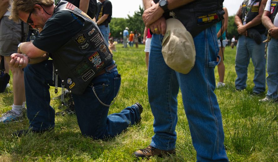 At left, Paul Kocic, who served in the U.S. Army from 1973-1998, bows his head during a moment of silence for fallen troops at the Rolling Thunder program near the National Mall during the Memorial Day weekend, in Washington, D.C., Sunday, May 29, 2011. The Rolling Thunder organization&#39;s mission is to bring awareness to the POW-MIA issue and to educate the public about how many American prisoners of war were left behind after all past wars. (Drew Angerer/The Washington Times)