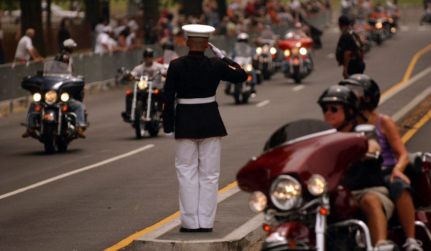Marine Staff Sgt. Tim Chambers from San Diego, California, stands at attention for hours to salute the tens of thousands of motorcyclists who participate in the annual Rolling Thunder Ride for Freedom in Washington. Photo by The Washington Times.