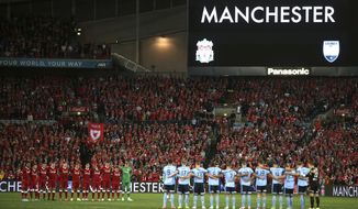 Liverpool FC, left, and Sydney FC pause for a minute&#x27;s silence before their friendly soccer match as a tribute to the victims of a bombing at Manchester, in Sydney, Wednesday, May 24, 2017. (AP Photo/Rick Rycroft)