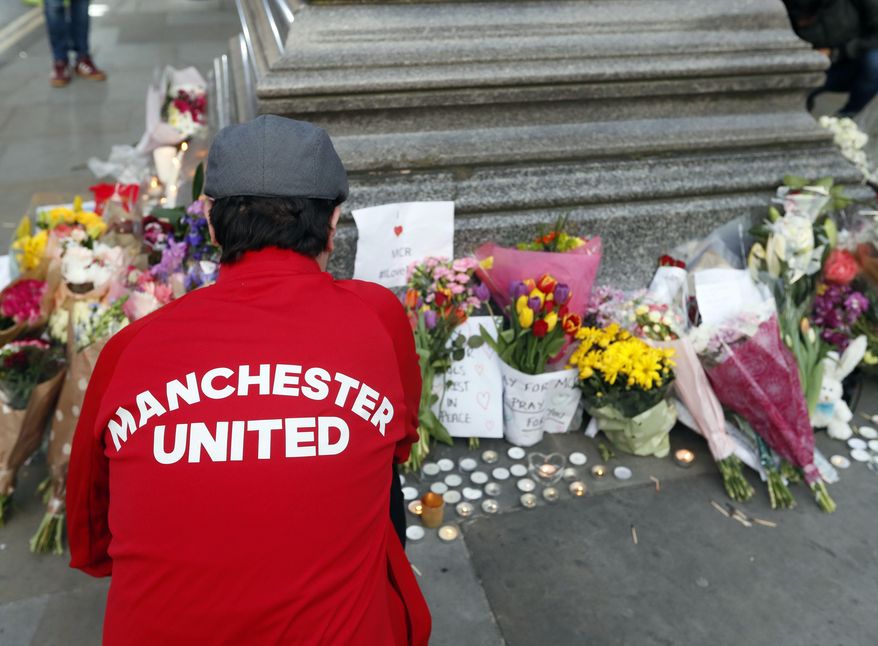 People lay flowers after a vigil in Albert Square, Manchester, England, Tuesday May 23, 2017, the day after the suicide attack at an Ariana Grande concert that left 22 people dead as it ended on Monday night. (AP Photo/Kirsty Wigglesworth)