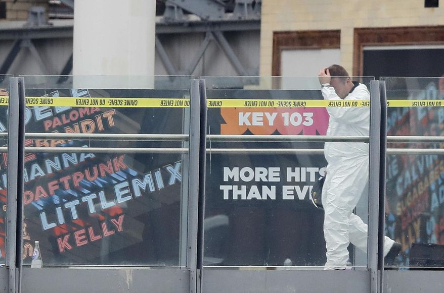 A forensic officer works near the Manchester Arena in Manchester, Wednesday, May 24, 2017. Britons will find armed troops at vital locations Wednesday after the official threat level was raised to its highest point following a suicide bombing that killed more than 20, as new details emerged about the bomber.(AP Photo/Kirsty Wigglesworth)