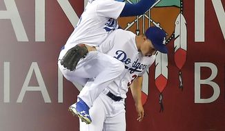Los Angeles Dodgers left fielder Cody Bellinger, left, lands on top of center fielder Joc Pederson as he makes a catch on a ball hit by St. Louis Cardinals&#39; Matt Carpenter during the seventh inning of a baseball game, Tuesday, May 23, 2017, in Los Angeles. (AP Photo/Mark J. Terrill)