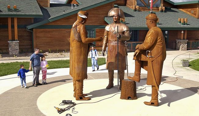 FILE - In this June 21, 2004 file photo, visitors walk past the figures of Chief Sheheke, left, Meriwether Lewis, center, and William Clark being installed in front of the Lewis and Clark Interpretive Center in Washburn, N.D. On Wednesday, May 24, 2017, a foundation announced it has transferred a nearly $700,000 endowment trust to support maintenance at the center. The state took over the center&#x27;s operations from the financially troubled foundation two years ago. (Tom Stromme/The Bismarck Tribune via AP, File)