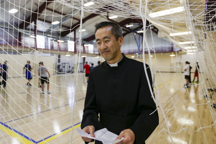 In this May 12, 2017 photo, the Rev. Joseph Lee, academic dean and basketball coach, leaves the gym at Our Lady of Guadaloup Seminary in Denton, Neb., as seminarians play basketball. Seminary life is extraordinarily regimented. Along with chanting four times a day and attending classes, they eat meals together and exercise together. (AP Photo/Nati Harnik)