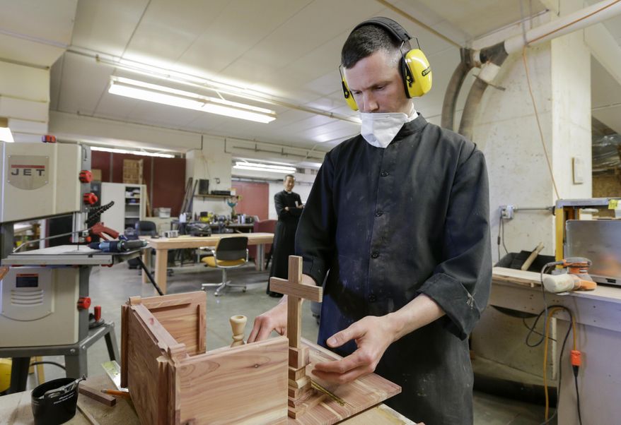 In this May 12, 2017 photo, the Rev. Benoit Guichard originally from Besancon, France, works on a portable alter at the wood shop at Our Lady of Guadaloup Seminary in Denton, Neb. Guichard is a member of the Priestly Fraternity of Saint Peter, who focus on traditional liturgy and Gregorian chants, which they use to pray four times a day. (AP Photo/Nati Harnik)