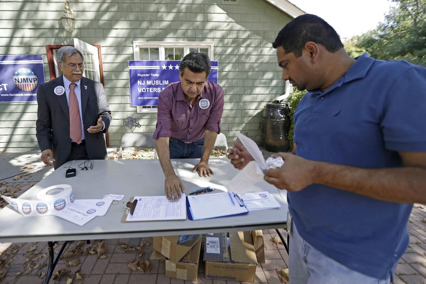 FILE - In this Sept. 23, 2016, file photo, Dr. Mohammad Ali Chaudry, left, president of the Islamic Society of Basking Ridge, N.J., and Shawn Butt, center, of Piscataway, N.J., provide voter registration information to Shahul Feroze, right, of South Brunswick, N.J., after a prayer service at the Bernards Township Community Center in Basking Ridge, N.J. The Bernards Township committee voted Tuesday, May 23, 2017, to settle two lawsuits over its denial of a proposed mosque, filed by the U.S. Justice Department and the Islamic Society of Basking Ridge. Some residents say their opposition is because of the selected location, not religious intolerance. (AP Photo/Julio Cortez, File)