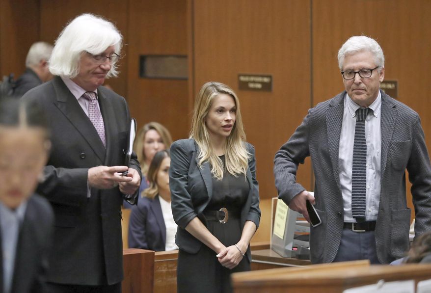 Model and Playboy bunny Danielle "Dani" Mathers, center, answers the judges's questions with her attorneys Tom Mesereau, left, and Dana M. Cole Wednesday, May 24, 2017, to answer charges related to her taking a photo of a naked, 71-year-old woman in a gym locker room and posting it on social media with insults about the woman's body, in Los Angeles County Superior Court in Los Angeles. She pleaded no contest and was sentenced to probation and 30 days of community service. (Frederick M. Brown/Pool photo via AP)