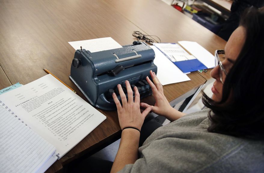 In this May 22, 2017 photo, inmate Nicole Belonga types on a Perkins Brailler at the New Hampshire Correctional Facility for Women in Goffstown, N.H., as she participates in an innovative program to learn how to translate books into braille. The translated books will go to schools for the blind across the country. (AP Photo/Elise Amendola)
