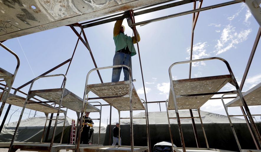 Maricopa County Sheriff personnel break down a tent in the Tent City Jail, Wednesday, May 24, 2017, in Phoenix. Crews have started to dismantle some of the tents in the controversial outdoor jail complex in Phoenix that's in the process of being closed by the metro area's new sheriff. (AP Photo/Matt York)