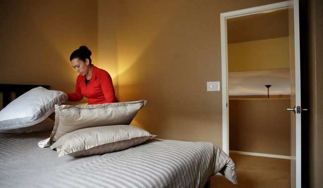 Jennifer Mesa cleans up a bedroom in the home of Randy Tussing, an Airbnb host in Las Vegas. More than 340,000 people passed on Nevada&#x27;s hotel rooms last year and opted instead to book a place to stay using the short-term rental service. (Associated Press)
