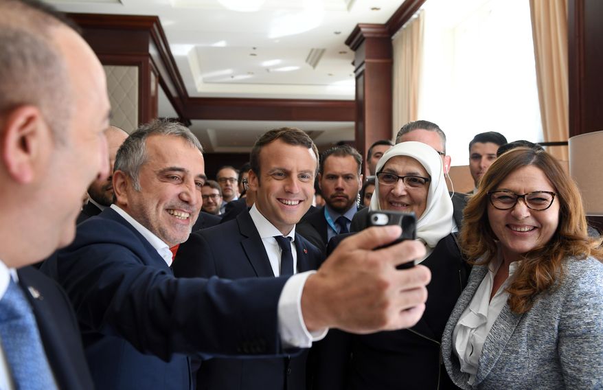French President Emmanuel Macron, centre, poses for a selfie with members of the Turkish delegation during a meeting which is on the sidelines of the NATO summit, in Brussels, on Thursday May 25, 2017. (Eric Feferberg /Pool via AP)