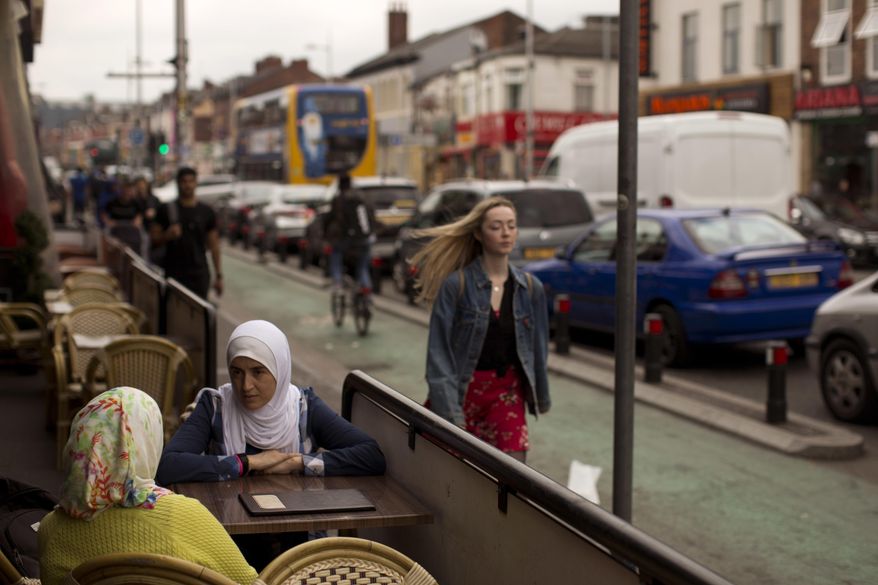 Two women sit in a bar in Curry Street in Manchester, Britain, Wednesday, May 24, 2017. On the Manchester street they call the "Curry Mile," there are very few Indian or Pakistani restaurants left. In a sign of the ever-changing face of this proudly multiethnic city, these days a hungry diner can choose between Halal snacks from Beirut, kebabs from Afghanistan or garishly colored sweets from India, among many others. (AP Photo/Emilio Morenatti)