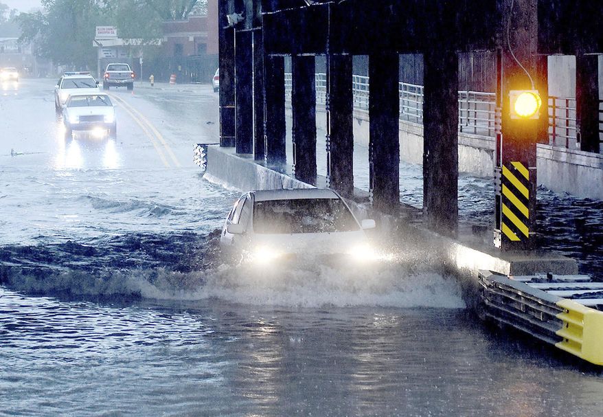 A car is partially submerged as it travels beneath a railroad underpass in Fort Wayne, Ind., on Thursday, May 25, 2017, following heavy rains that sparked flash flooding in the northeastern Indiana city. (Samuel Hoffman/The Journal-Gazette via AP)